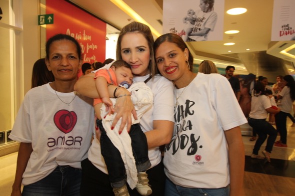 Áurea Negromonte, voluntária da Amar, com Juan no colo e a avó Jacinete Araújo e a mãe Daniele Santos. Crédito: Nando Chiappetta / DP 